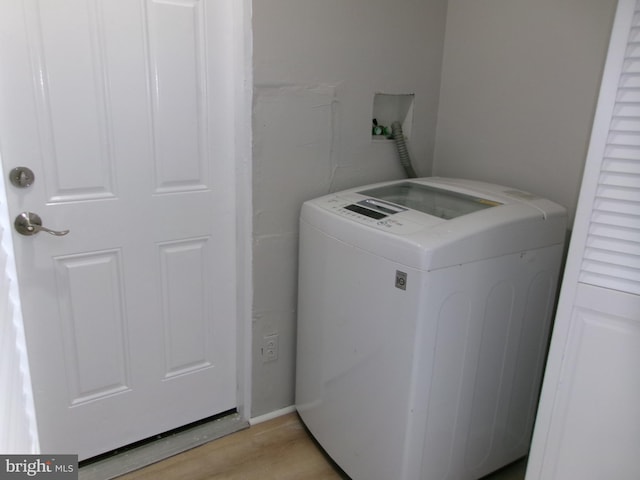 clothes washing area featuring washer / clothes dryer and light wood-type flooring