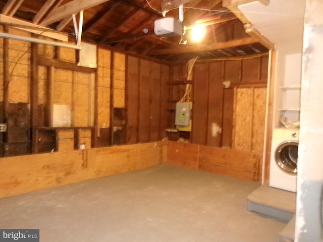 basement with electric panel and washer / dryer