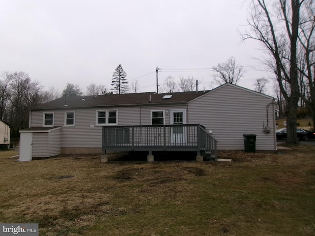 rear view of property featuring a yard and a deck