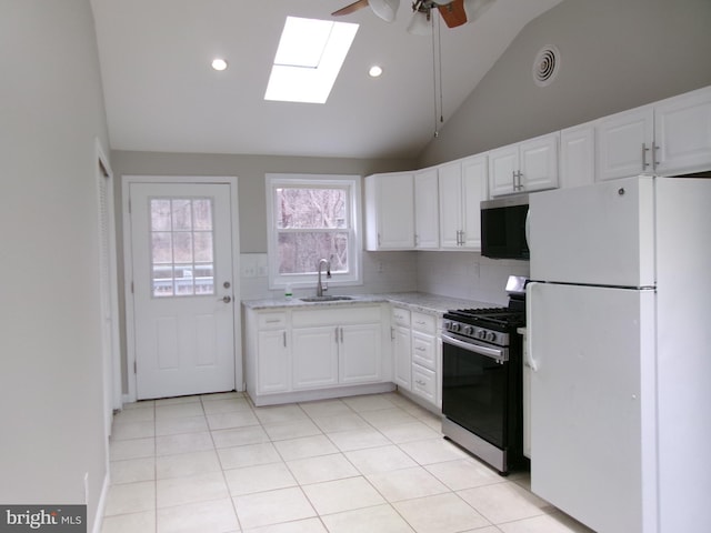 kitchen featuring sink, white refrigerator, white cabinets, and stainless steel gas range oven