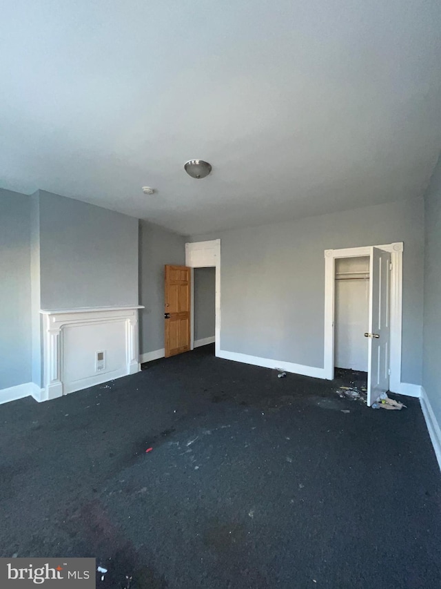 unfurnished living room featuring dark carpet