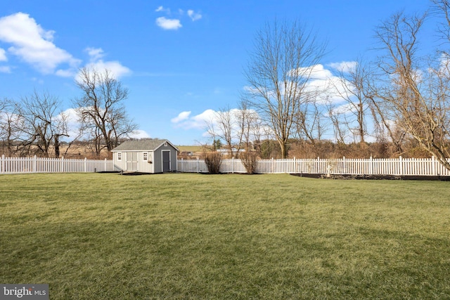 view of yard with an outbuilding, a storage unit, and a fenced backyard