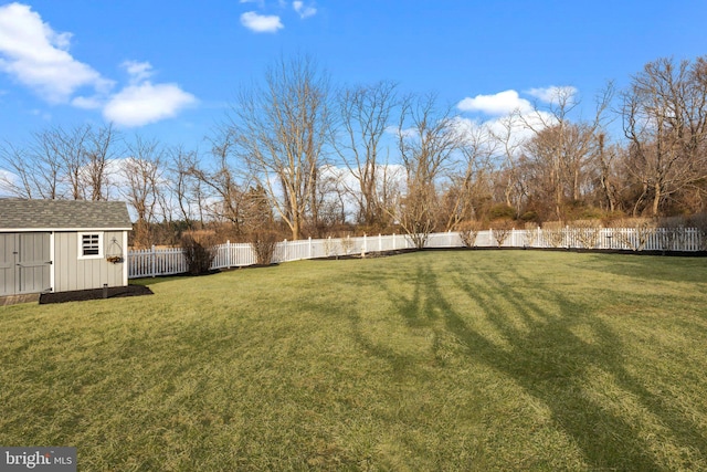 view of yard with an outbuilding, a fenced backyard, and a shed