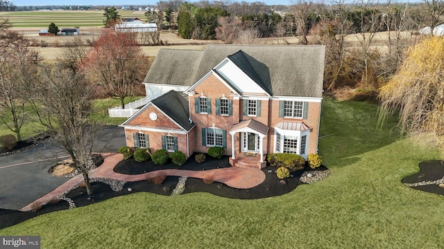 view of front of home featuring brick siding and a front yard