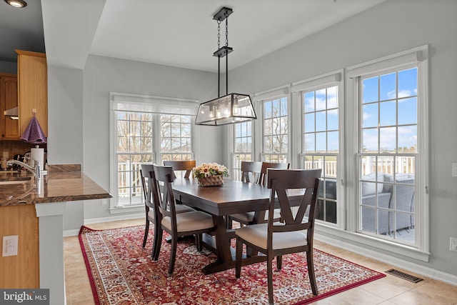 dining space featuring light tile patterned floors, baseboards, and visible vents