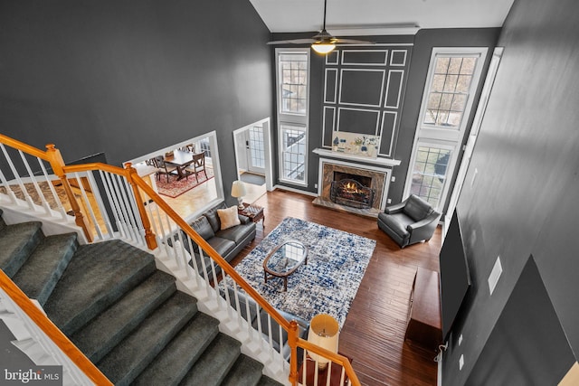 living area featuring plenty of natural light, a high ceiling, and a ceiling fan