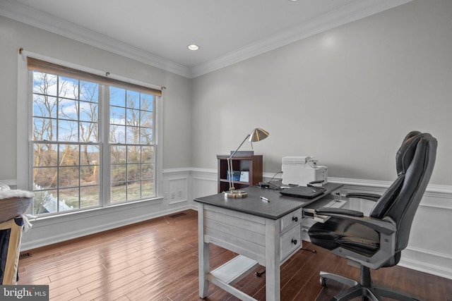 office space with visible vents, ornamental molding, dark wood-type flooring, wainscoting, and a decorative wall