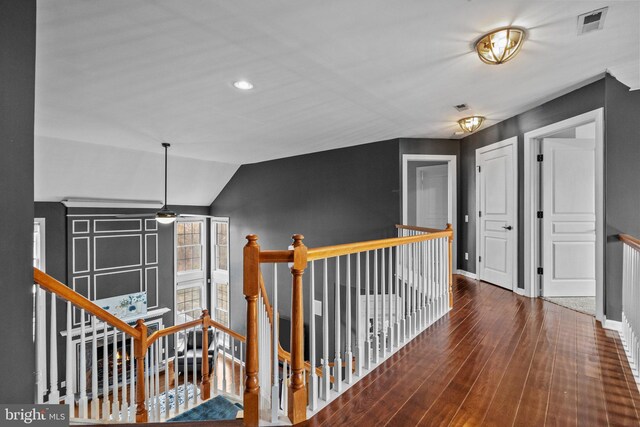 hall featuring baseboards, an upstairs landing, lofted ceiling, and wood finished floors