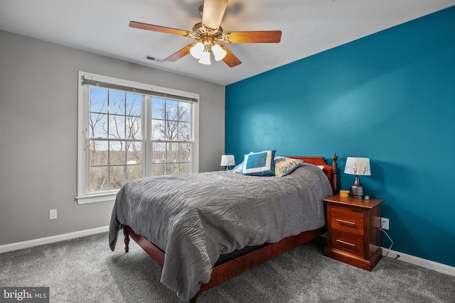 carpeted bedroom with multiple windows, baseboards, visible vents, and ceiling fan