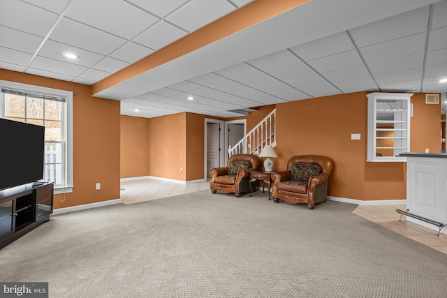 sitting room featuring visible vents, a drop ceiling, stairway, carpet, and baseboards