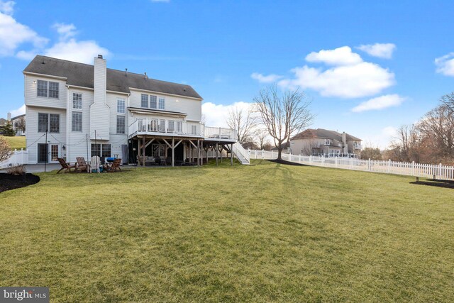 rear view of property with stairway, a wooden deck, a fenced backyard, and a chimney