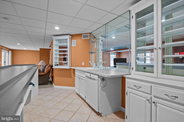 kitchen featuring light tile patterned floors, visible vents, white dishwasher, a sink, and white cabinets