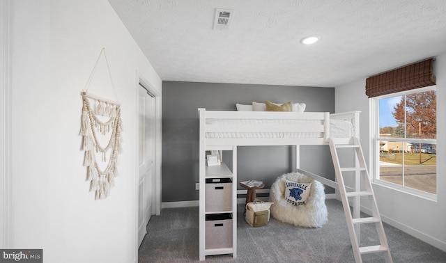 carpeted bedroom featuring a textured ceiling