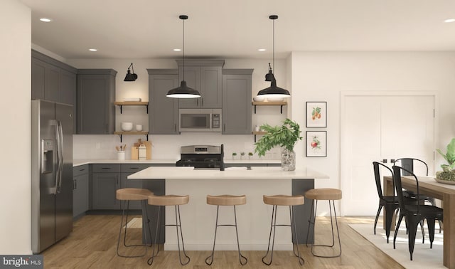 kitchen featuring a kitchen bar, gray cabinetry, stainless steel appliances, and pendant lighting