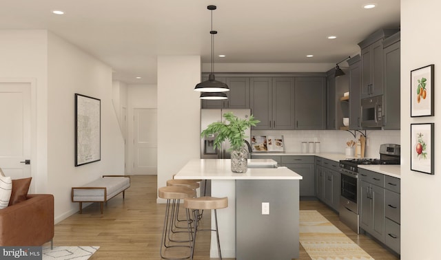 kitchen with a center island, decorative light fixtures, tasteful backsplash, appliances with stainless steel finishes, and a kitchen breakfast bar