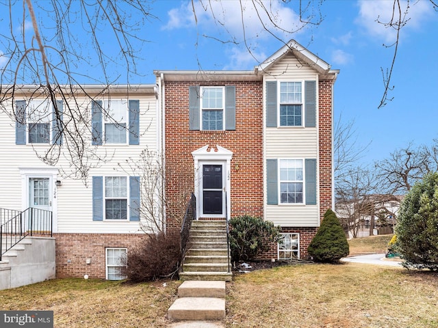 townhome / multi-family property featuring a front lawn