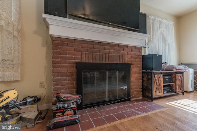 details featuring a brick fireplace and hardwood / wood-style floors