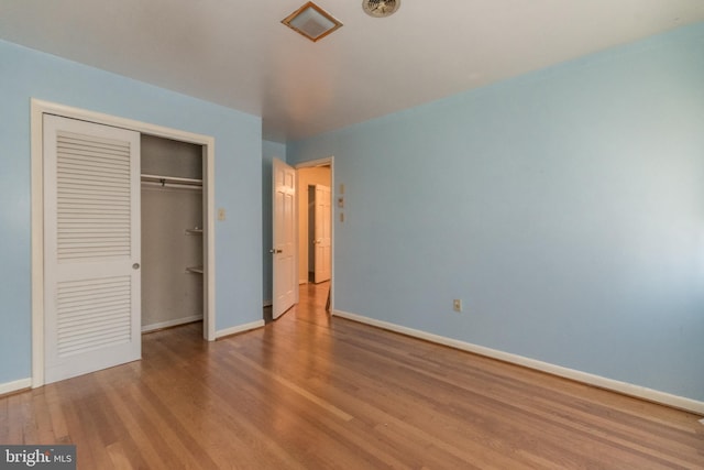 unfurnished bedroom with light wood-type flooring and a closet