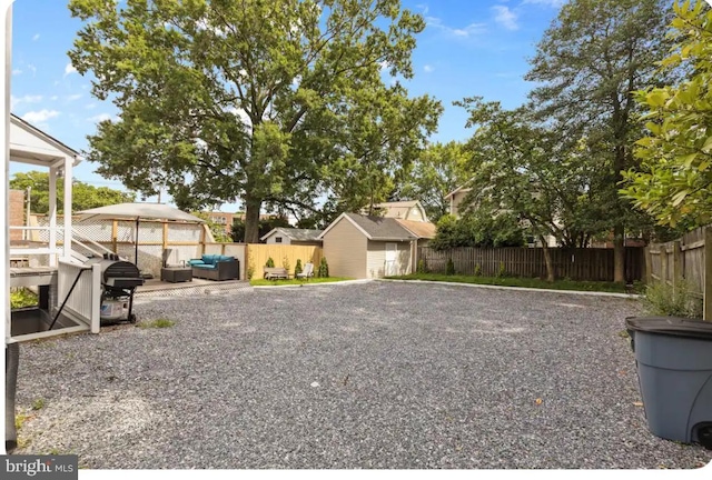 view of yard with a patio area, an outdoor living space, and a storage unit