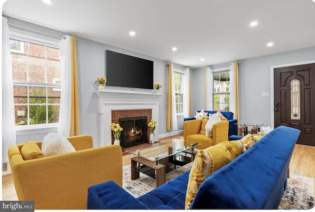 living room with a fireplace and light wood-type flooring