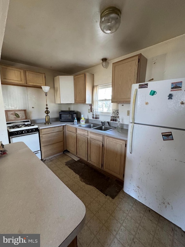 kitchen featuring white appliances, sink, and light brown cabinetry