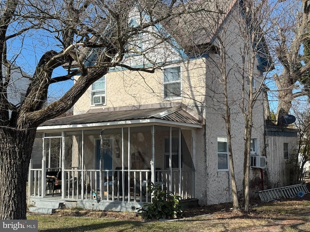 view of front of home featuring cooling unit and a sunroom