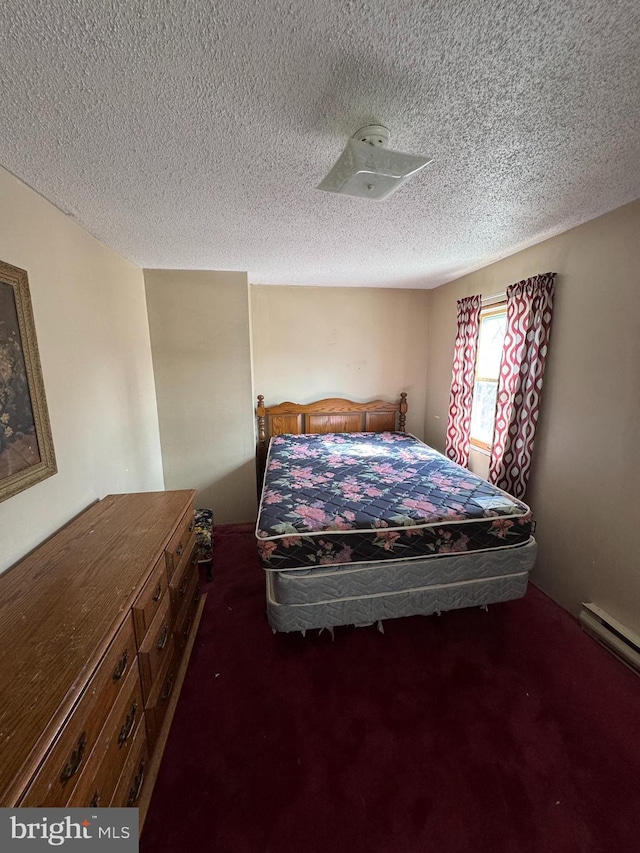 bedroom featuring dark colored carpet and a textured ceiling