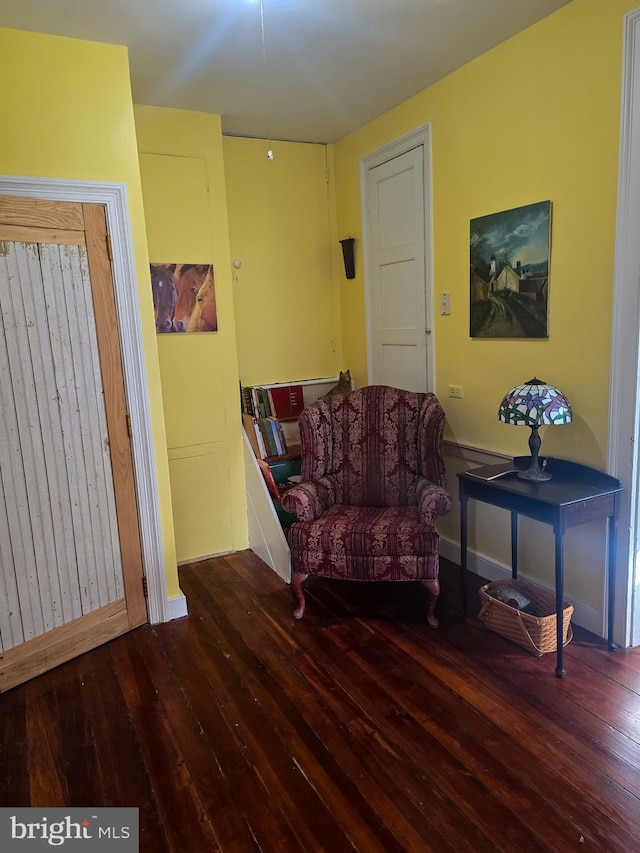 sitting room with baseboards and wood finished floors