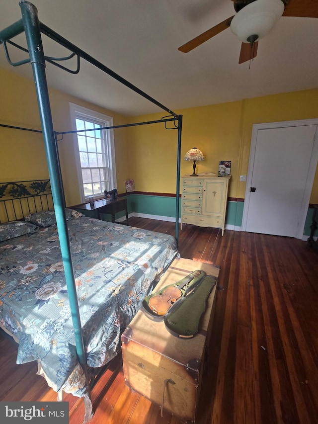 bedroom with ceiling fan, baseboards, and wood finished floors