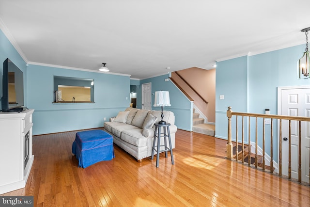 living room featuring ornamental molding, hardwood / wood-style flooring, and a chandelier