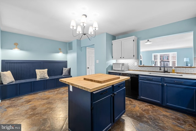 kitchen featuring a center island, black dishwasher, blue cabinets, sink, and white cabinets