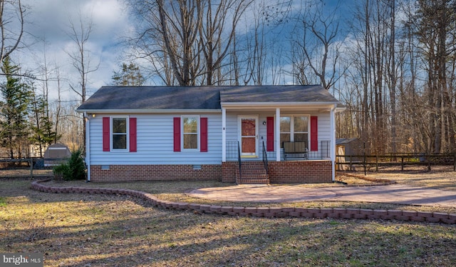 view of front of house featuring an outbuilding, fence, crawl space, a shed, and a front lawn