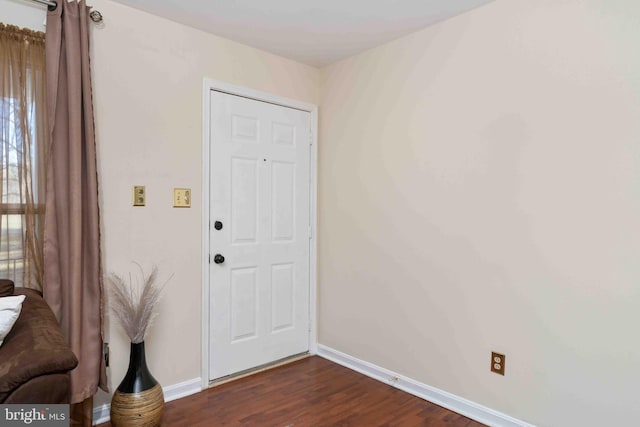 entryway with dark wood finished floors and baseboards