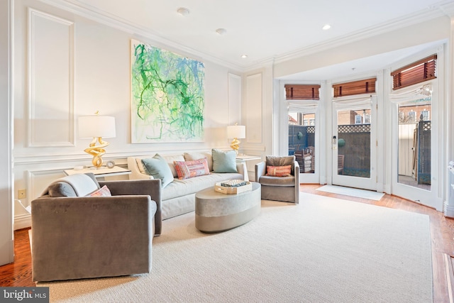 sitting room with crown molding and wood-type flooring