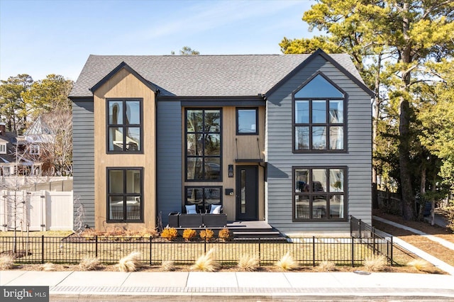 view of front of home featuring a fenced front yard and a shingled roof