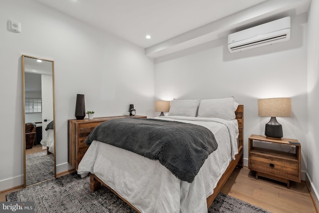 bedroom with baseboards, a wall mounted AC, wood finished floors, and recessed lighting