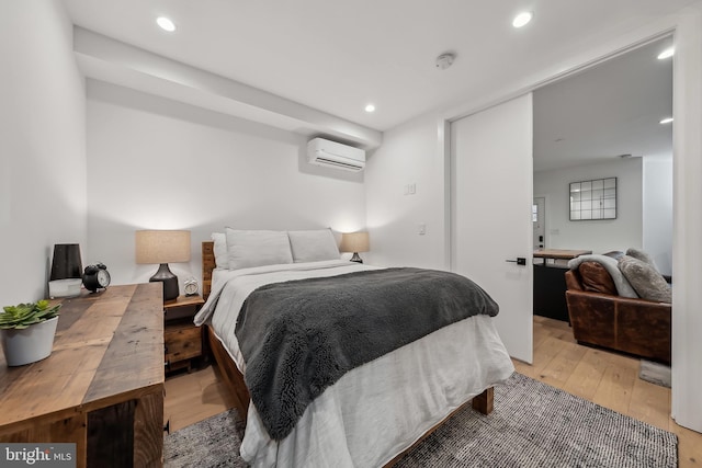 bedroom with recessed lighting, an AC wall unit, and light wood-style flooring