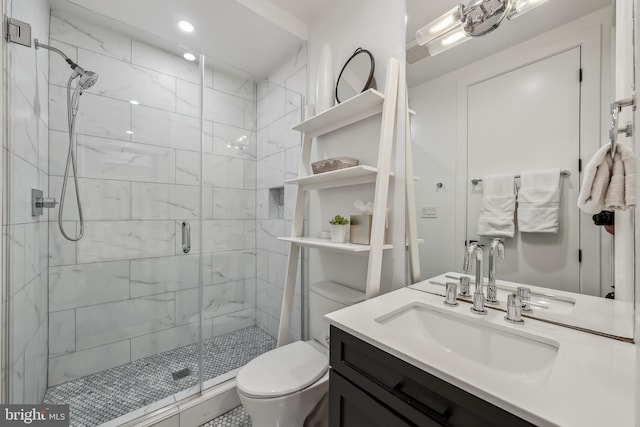 bathroom with toilet, a stall shower, and vanity