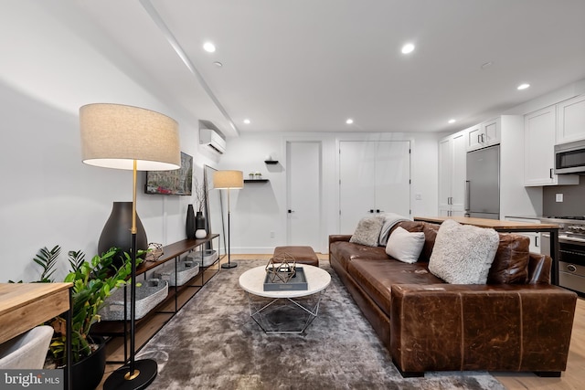 living area featuring a wall mounted air conditioner, wood finished floors, and recessed lighting