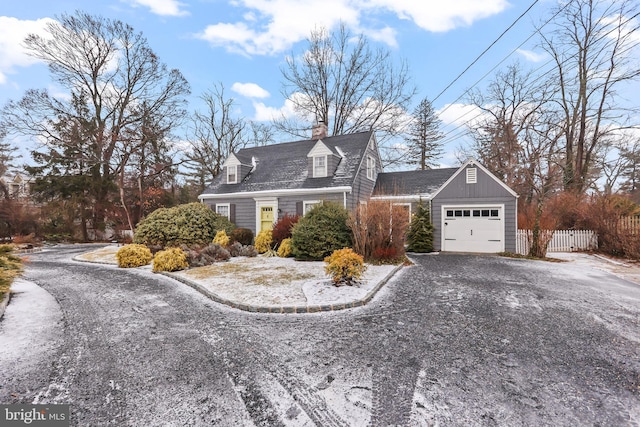 view of front of house featuring gravel driveway, an attached garage, a chimney, and fence