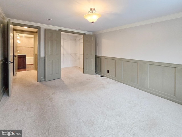 unfurnished bedroom featuring a closet, crown molding, and light colored carpet