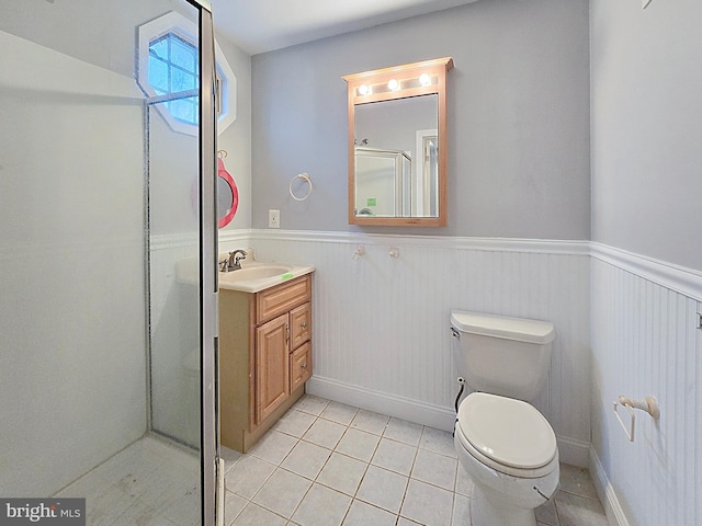 bathroom with tile patterned floors, toilet, vanity, and an enclosed shower