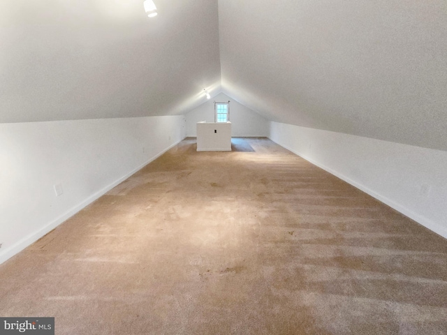 bonus room with lofted ceiling and light colored carpet