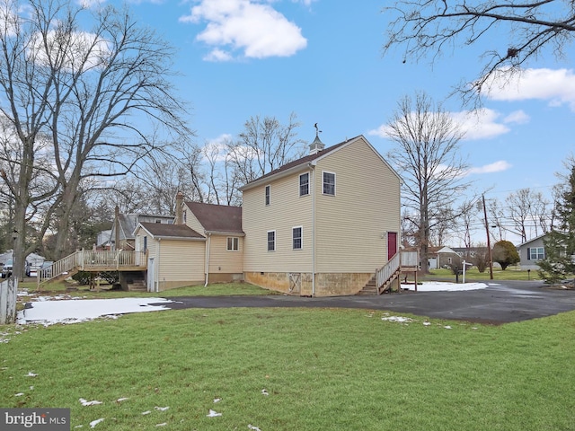 rear view of house with a lawn and a deck