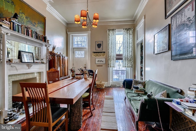 dining room featuring dark wood-type flooring, crown molding, and an inviting chandelier