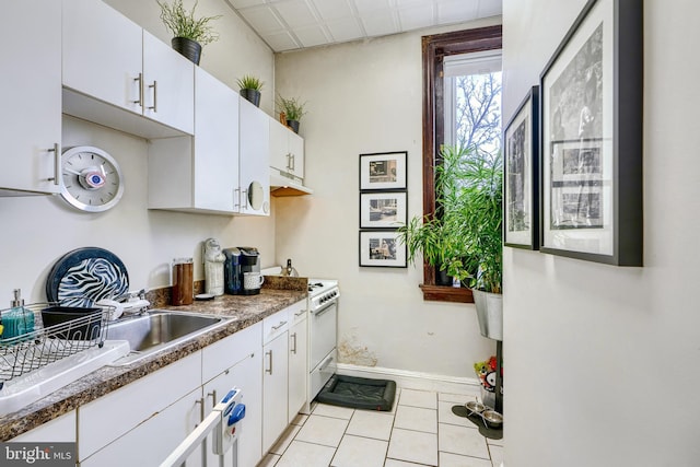 kitchen with white cabinetry, white range with gas stovetop, sink, and light tile patterned floors