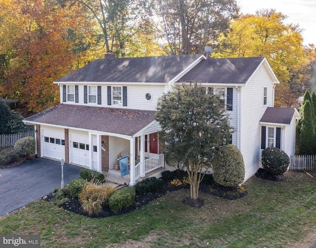 view of front of home with aphalt driveway, a chimney, a front yard, fence, and a garage