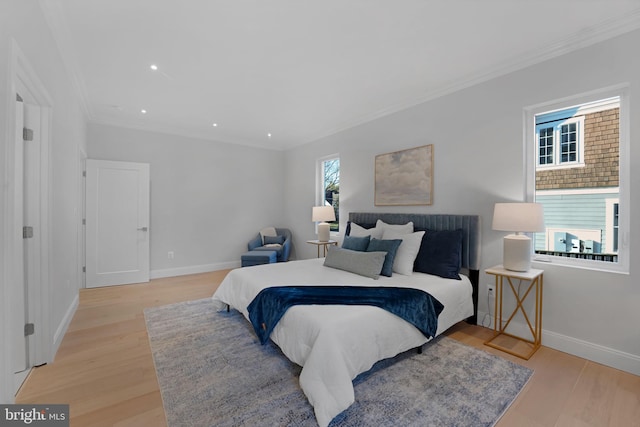 bedroom with light wood-type flooring, baseboards, and ornamental molding