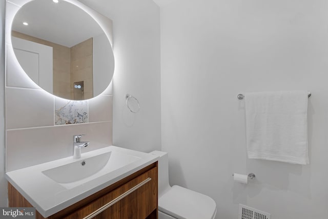 full bathroom with toilet, visible vents, and vanity