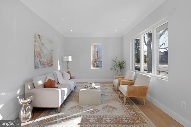 living area with recessed lighting, baseboards, wood finished floors, and ornamental molding